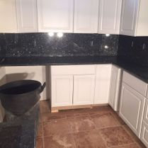 Black Stone Counter With White Cabinets